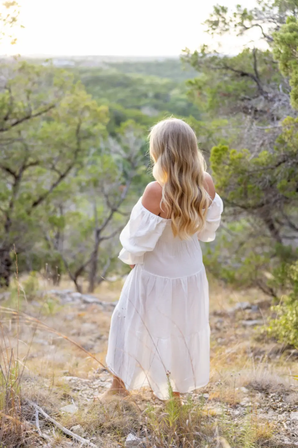 Mulher com vestido branco de linho em área externa, luz natural